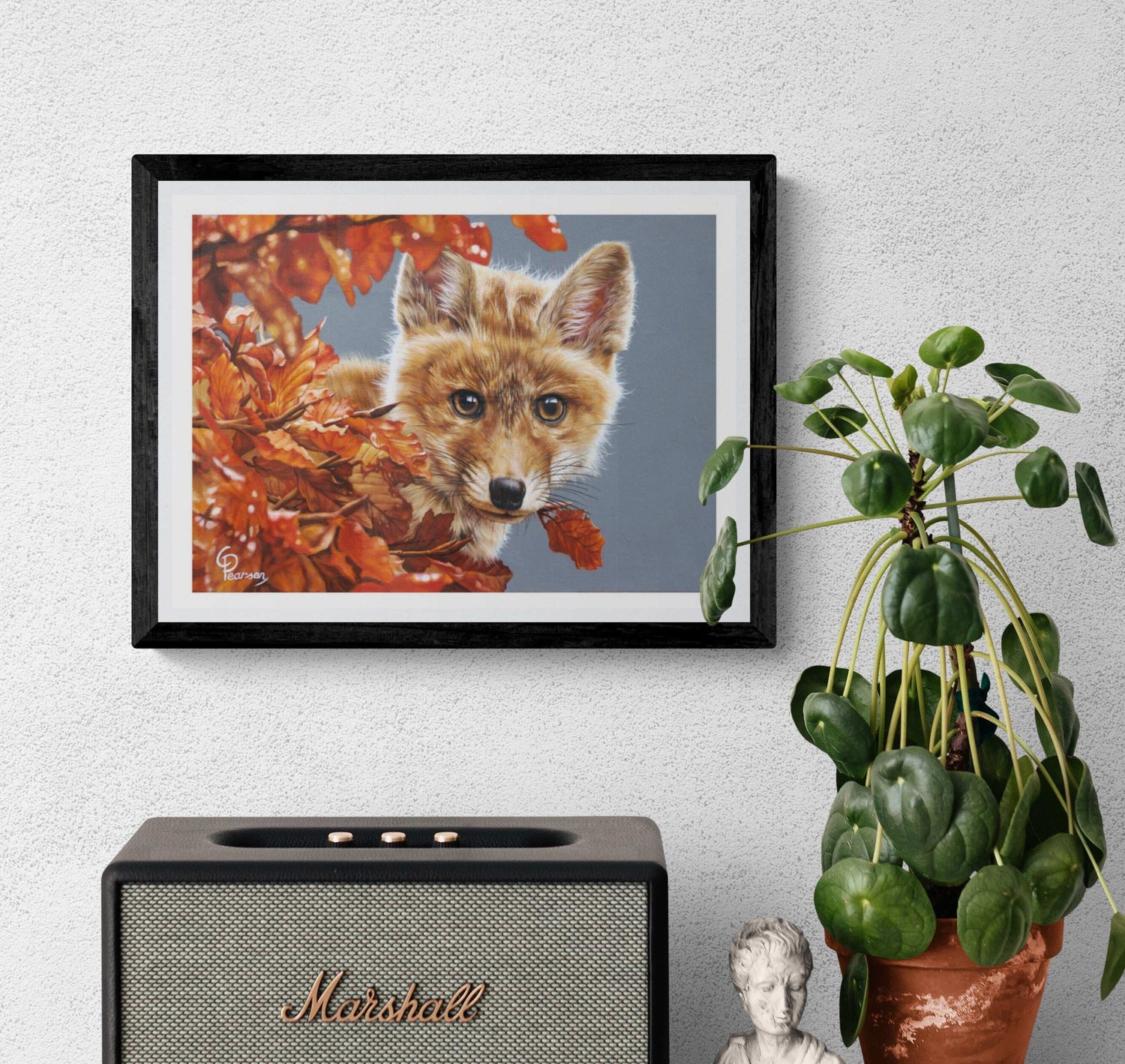 Framed picture of a fox among autumn leaves above a Marshall speaker on a wall.