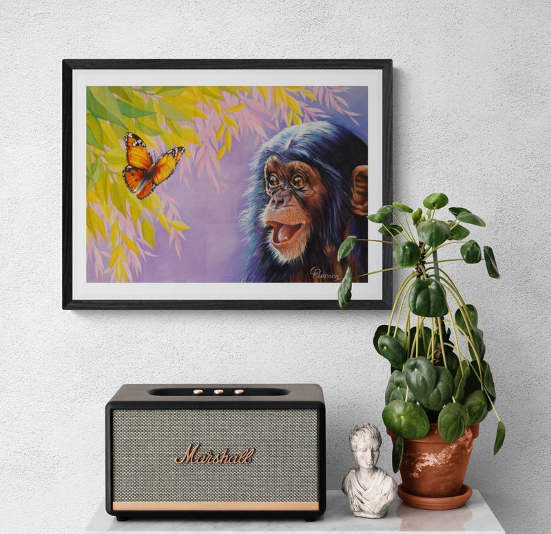 Framed artwork of a monkey and butterfly on a wall above a Marshall speaker and plant.