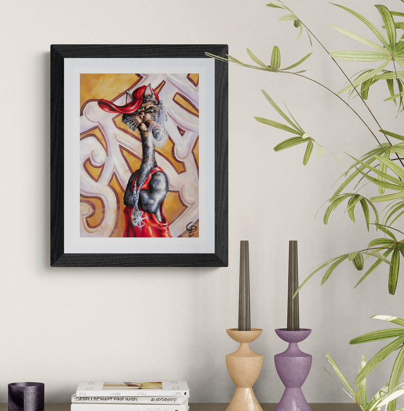 Framed artwork of cat on a wall with decorative candles and books below