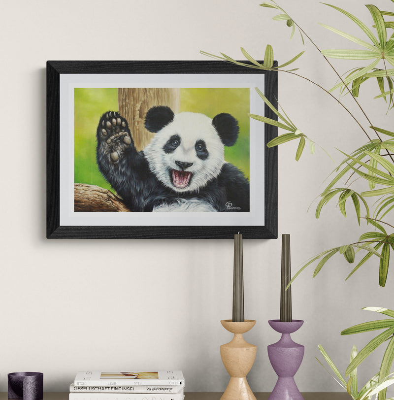 Framed painting of a panda bear on a wall with decorative candles and books below.