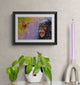 Framed artwork of a monkey and butterfly on a wall with decorative items below.