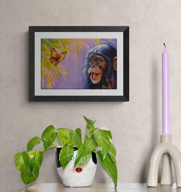 Framed artwork of a monkey and butterfly on a wall with decorative items below.