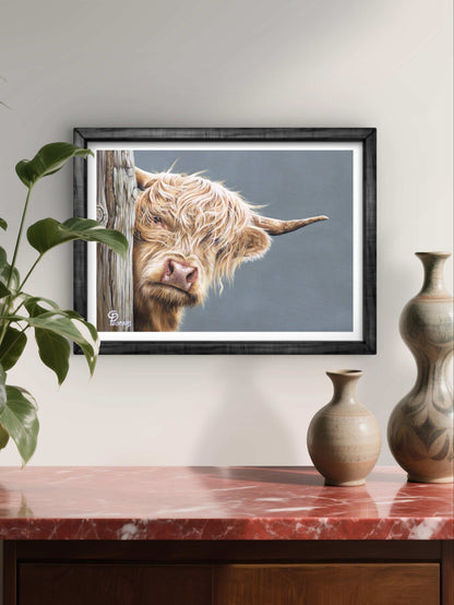 Framed picture of a Highland cow on a wall above a wooden cabinet with vases.