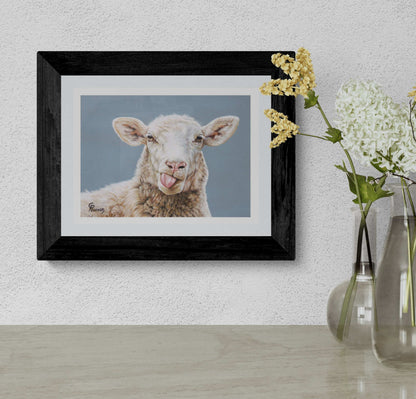 Framed picture of a lamb on a wall with a vase of flowers below.