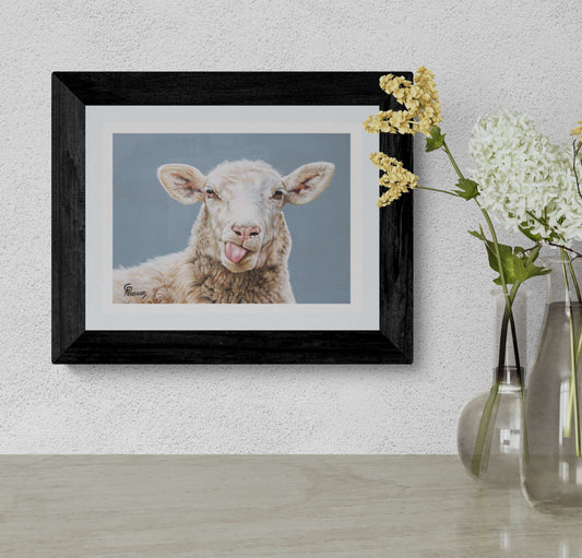 Framed picture of a lamb on a wall with a vase of flowers below.