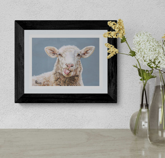 Framed picture of a lamb on a wall with a vase of flowers below.