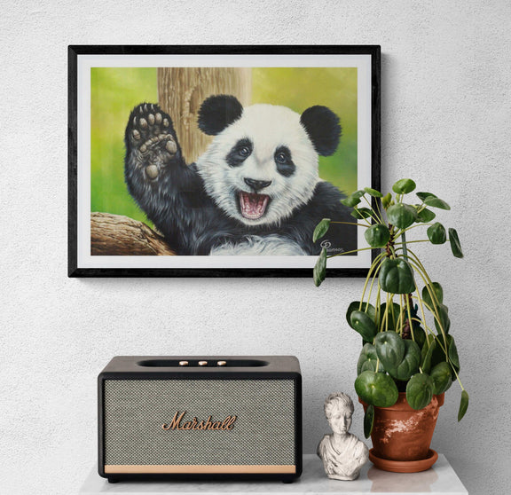 Framed picture of a panda, Marshall speaker, plant, and small statue on a white surface.
