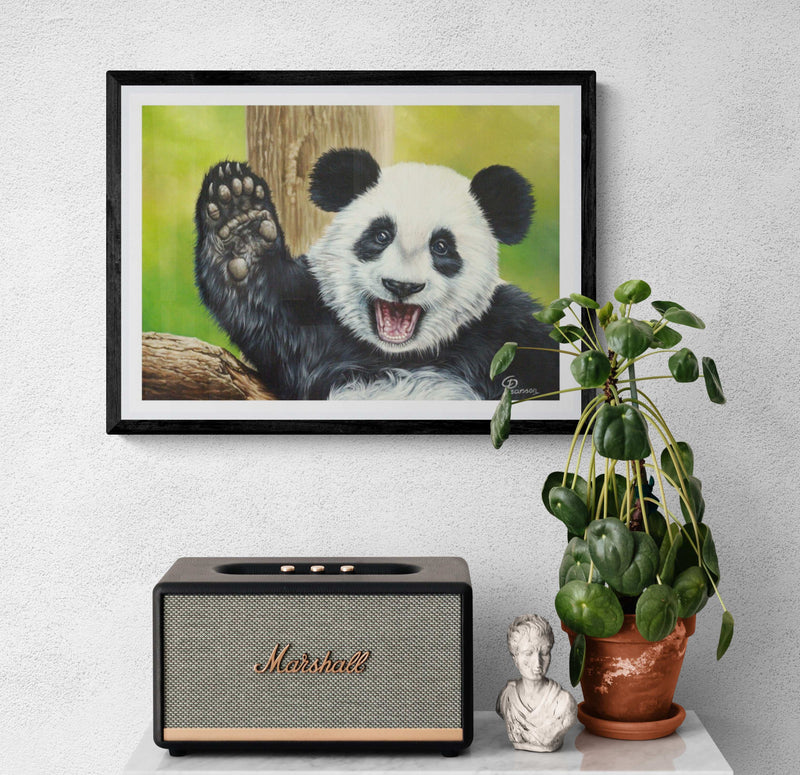 Framed picture of a panda, Marshall speaker, plant, and small statue on a white surface.