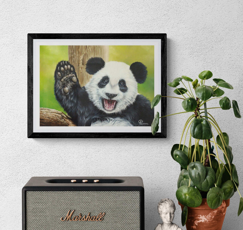 Framed picture of a panda waving, Marshall speaker, and potted plant on a white wall.