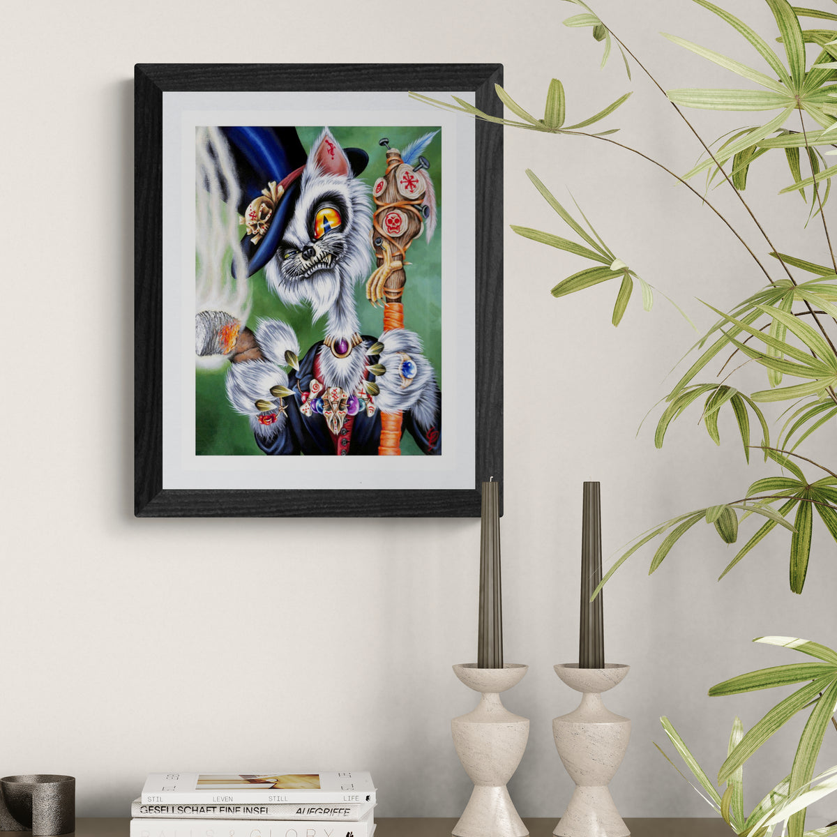 Framed artwork of a colorful cat with a hat on a wall next to decorative candles and plants.