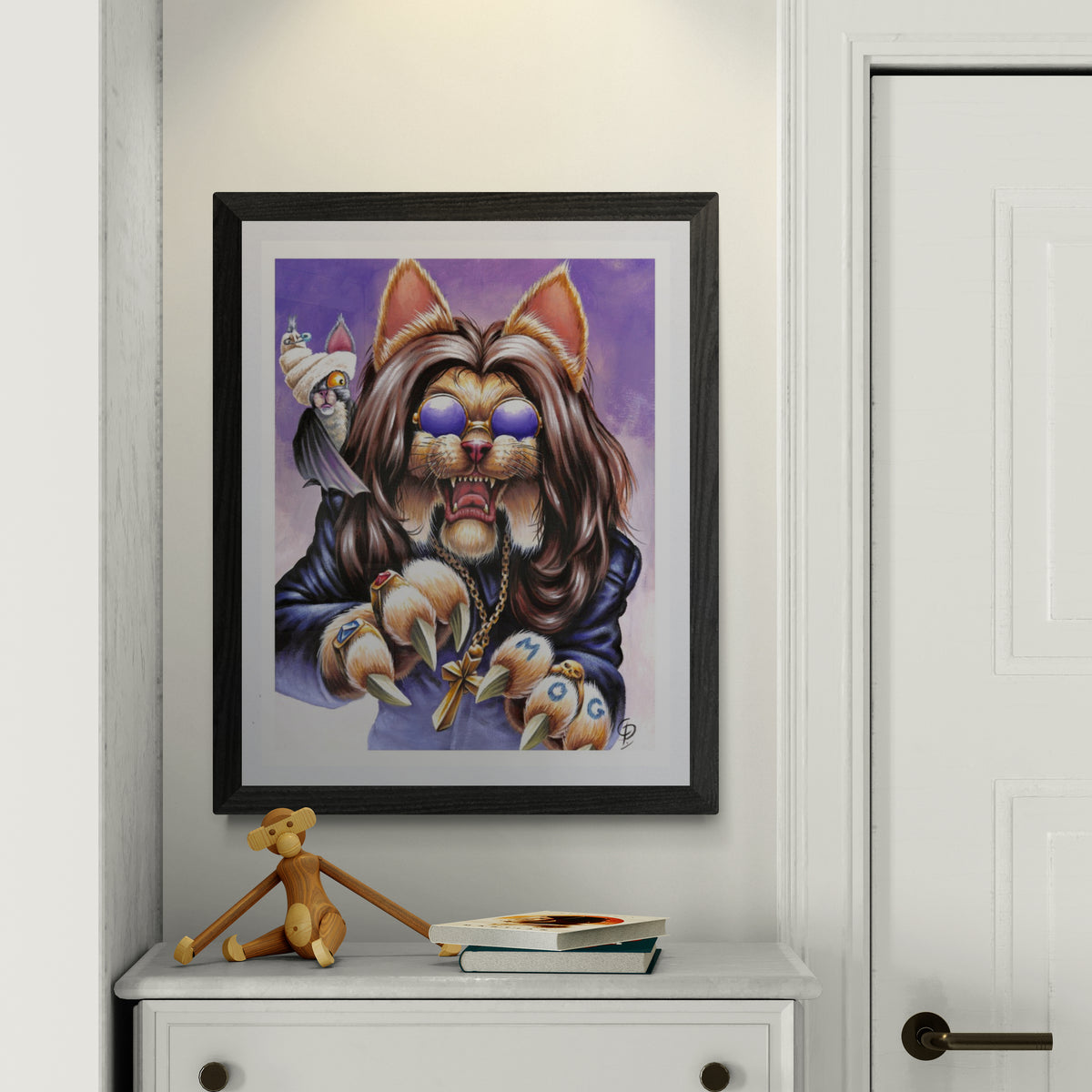 Framed artwork of a stylized cat with a purple background on a white wall.