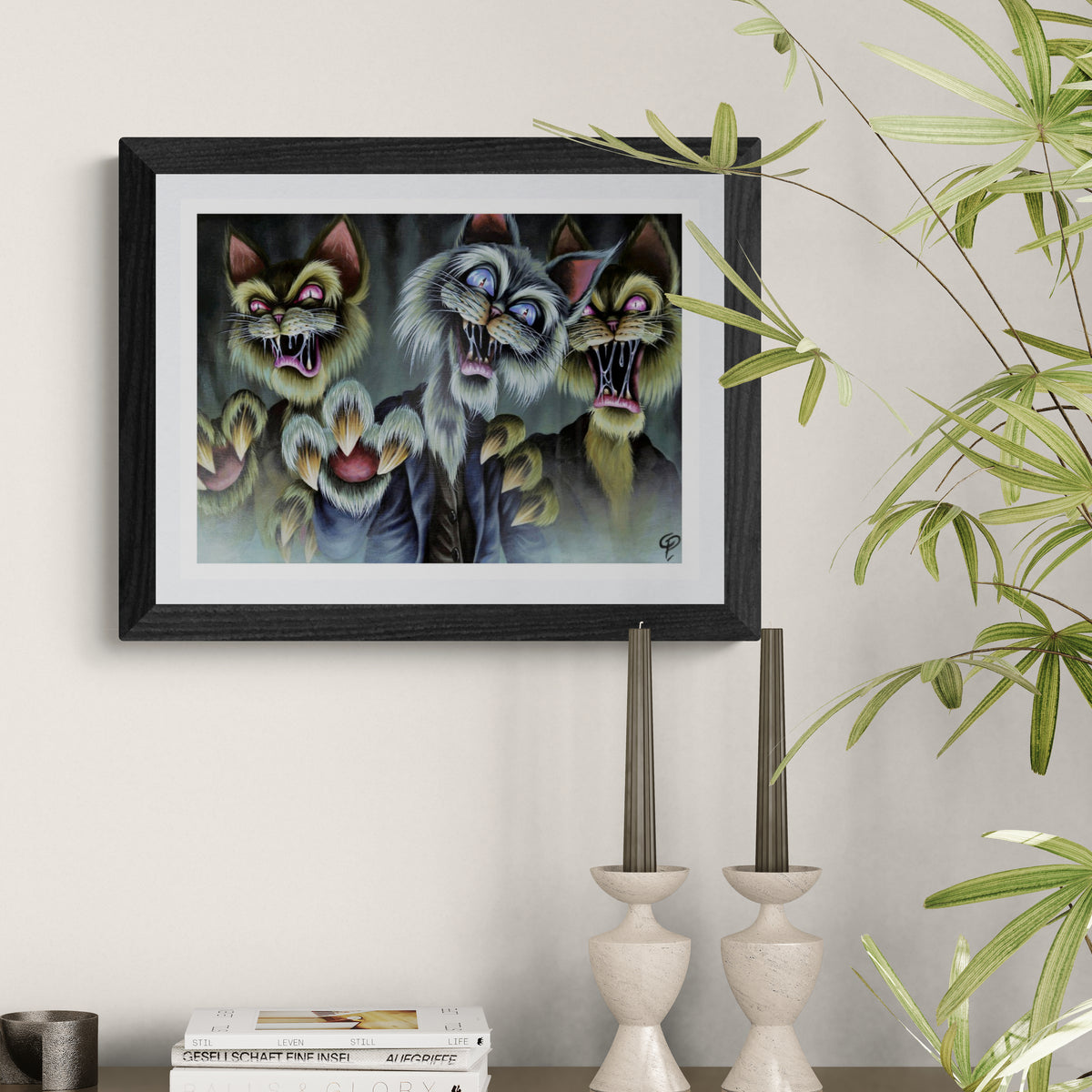 Framed artwork of three anthropomorphic zombie cats on a wall with decorative elements.