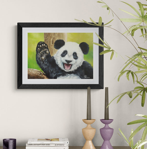 Framed painting of a panda bear on a wall with decorative candles and books below.