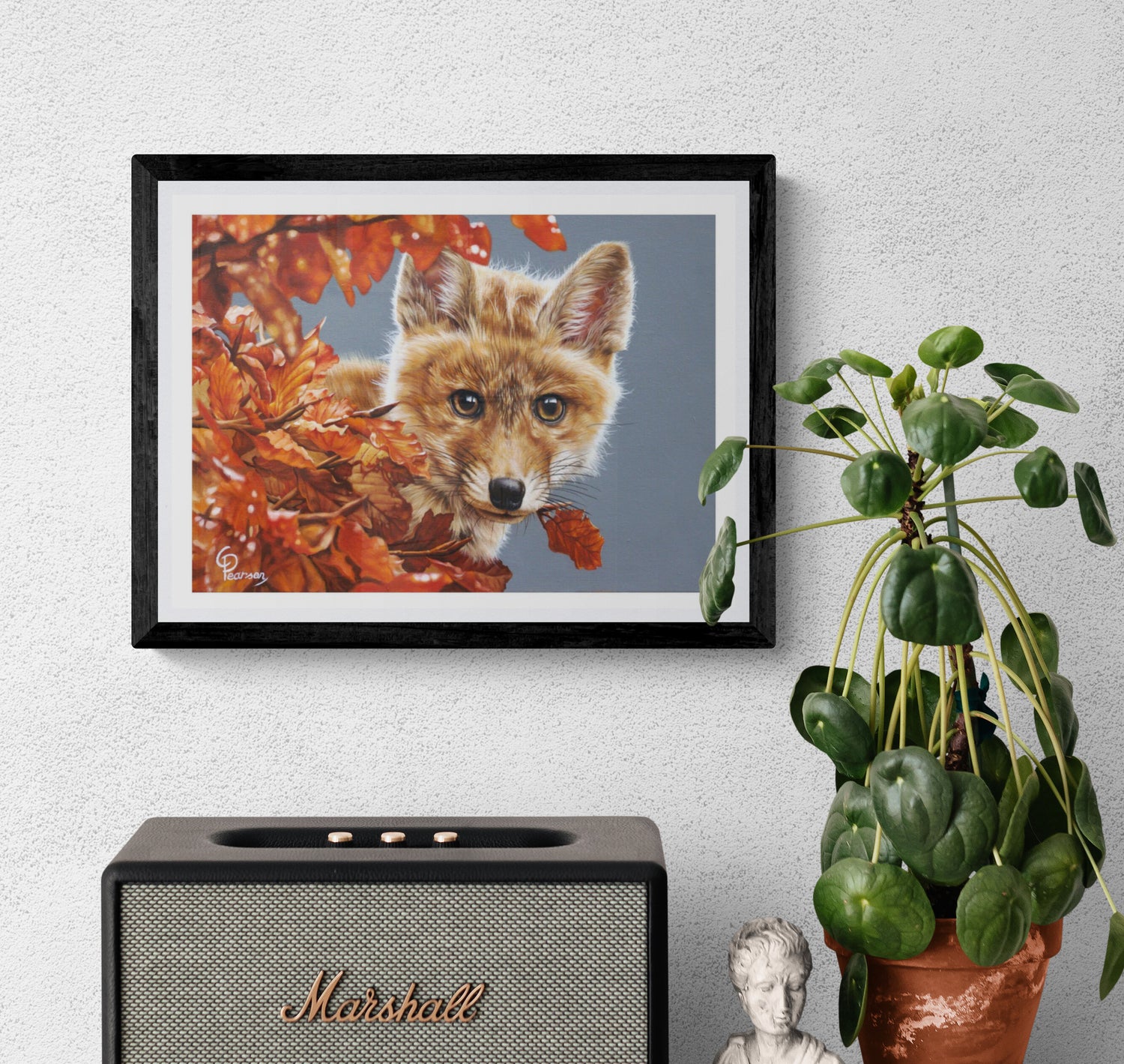 Framed picture of a fox among autumn leaves above a Marshall speaker on a wall.