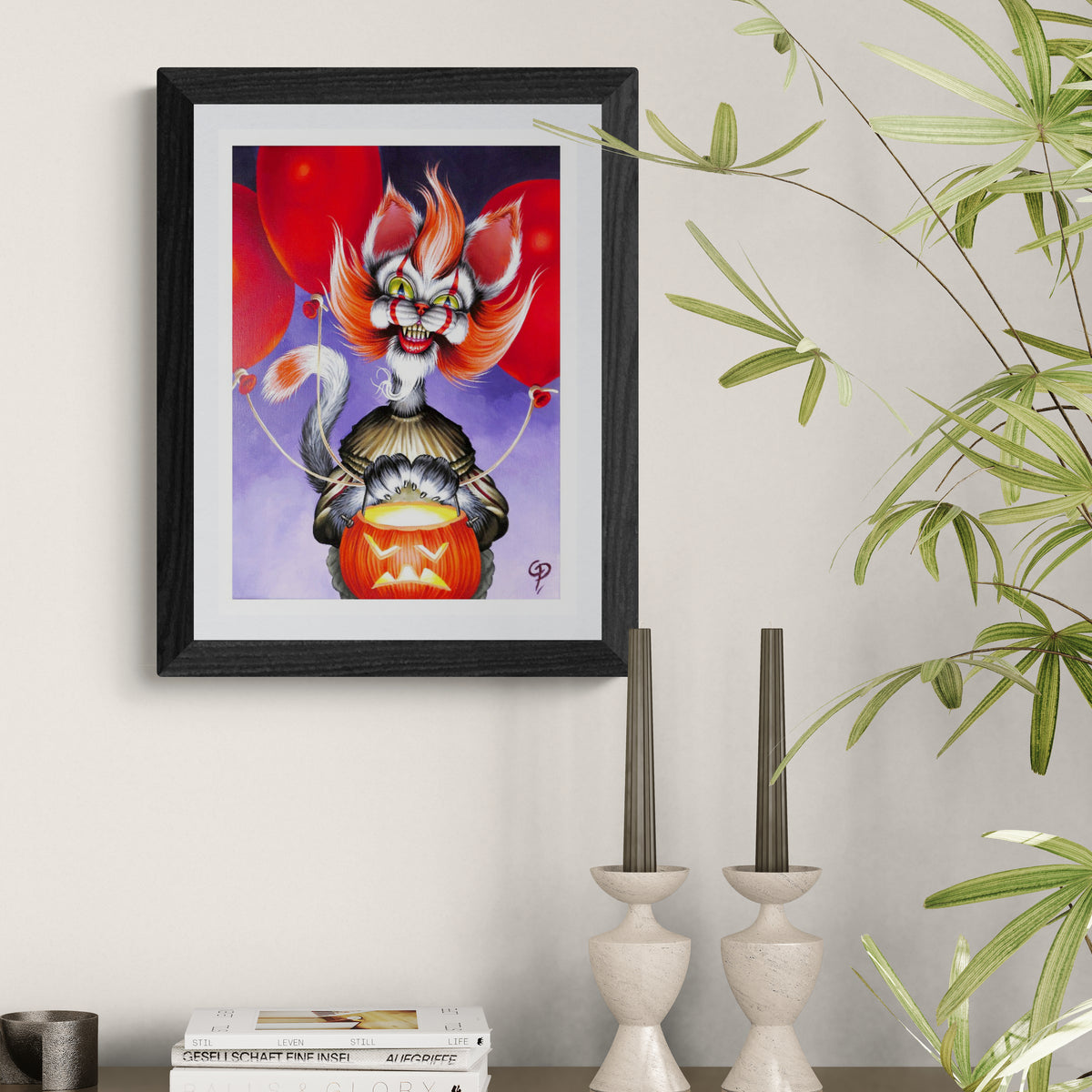 Framed artwork of a stylized cat-like creature with red eyes and orange hair on a white wall.