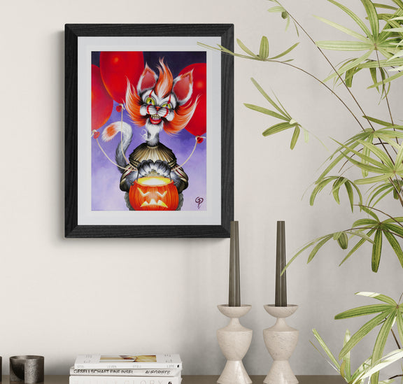 Framed artwork of a stylized cat-like creature with red eyes and orange hair on a white wall.