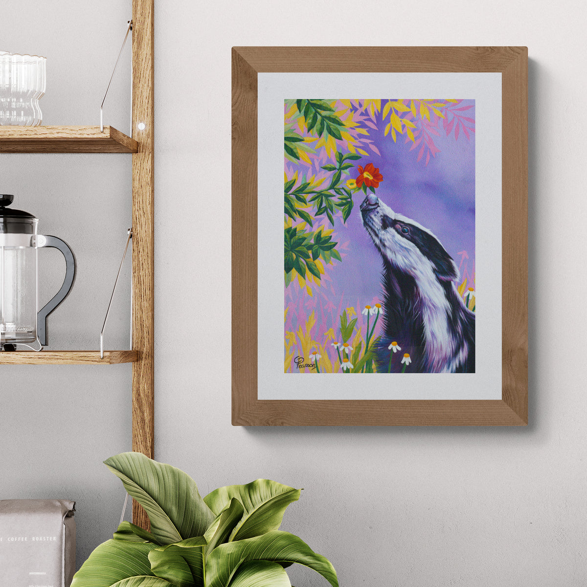 Framed painting of a badger with flowers on a wall above a plant