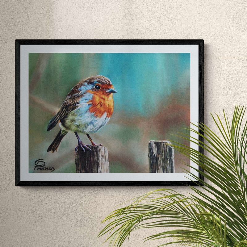 Framed artwork of a bird on a wooden post against a beige wall with a plant.